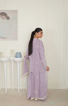 تصویر گیلری ویور میں لوڈ کریں، A woman wearing a lavender purple traditional outfit with white embroidered details and a matching headscarf, standing in a bright, white-paneled room.