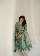Load image into Gallery viewer, Woman wearing a traditional green outfit with gold embroidery against a white background
