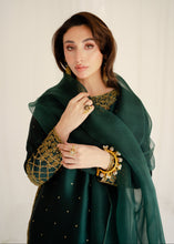 Load image into Gallery viewer, Woman wearing a dark green traditional outfit with gold embroidery on a white background