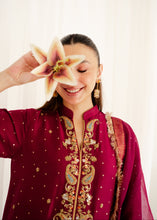 Load image into Gallery viewer, Woman in a red embroidered traditional outfit holding a flower against a white background