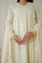 Load image into Gallery viewer, A close-up of a person wearing a cream-colored embroidered traditional outfit with matching sheer dupatta, featuring delicate floral embroidery and gold accents.
