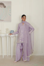 تصویر گیلری ویور میں لوڈ کریں، A woman models a light purple/lavender traditional outfit with matching pants and dupatta in a bright, white-paneled room. The outfit features subtle white embroidery and scalloped edges.
