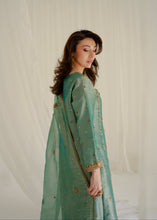 Load image into Gallery viewer, Woman wearing a green traditional outfit with gold details against a white background
