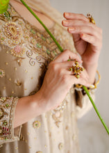 Load image into Gallery viewer, Close-up of hands holding a green flower with embroidered fabric in the background
